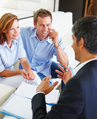 A couple talks to a loan officer. They are applying for a loan.